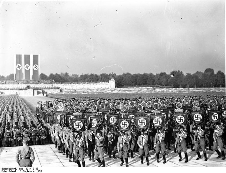 "Übersicht während des Fahnenaufmarsches", schwarz-weiß Photographie, Deutschland, 10. September 1938, Photograph: Scherl; Bildquelle: Deutsches Bundesarchiv, Bild 183-H12148, Quelle: http://commons.wikimedia.org/wiki/File:Bundesarchiv_Bild_183-H12148,_N%C3%BCrnberg,_Reichsparteitag.jpg ).Diese Datei ist unter der Creative Commons-Lizenz Namensnennung-Weitergabe unter gleichen Bedingungen 3.0 Deutschland lizenziert.