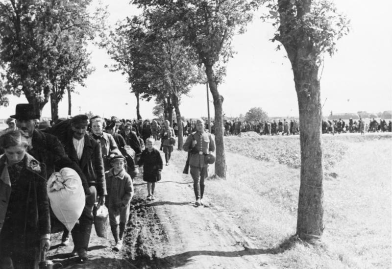 Vertriebene Polen ziehen unter Bewachung von bewaffneten Wehrmachtssoldaten zum Bahnhof in Schwarzenau (Czerniejewo) bei Gnesen (Gniezno), schwarz-weiß Photographie, Deutschland, 1939, Photograph: Wilhelm Holtfreter; Bildquelle: Deutsches Bundesarchiv (German Federal Archive), R 49 Bild-0131, wikimedia commons, http://de.wikipedia.org/w/index.php?title=Datei:Bundesarchiv_R_49_Bild-0138,_Polen,_Wartheland,_Aussiedlung_von_Polen.jpg&filetimestamp=20081209225121.